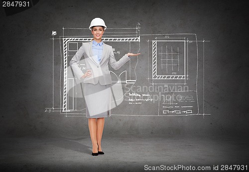 Image of businesswoman in helmet holding something on palm