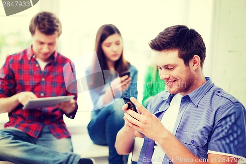Image of student looking into smartphone at school