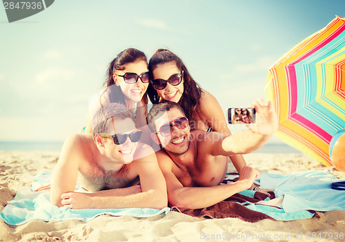 Image of group of people taking picture with smartphone