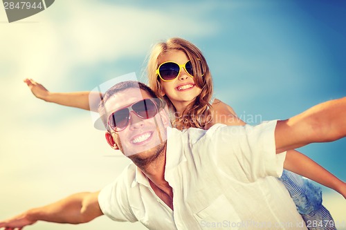 Image of happy father and child in sunglasses over blue sky