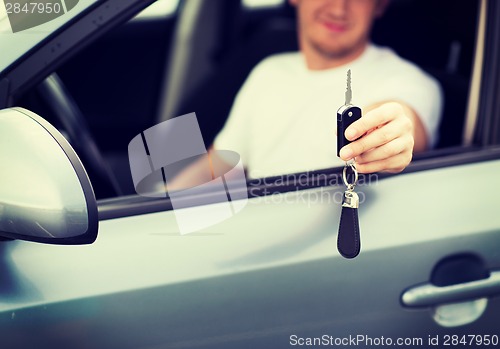 Image of man with car key outside