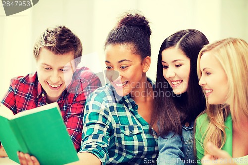 Image of students reading book at school