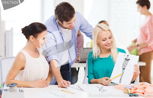 Image of smiling fashion designers working in office