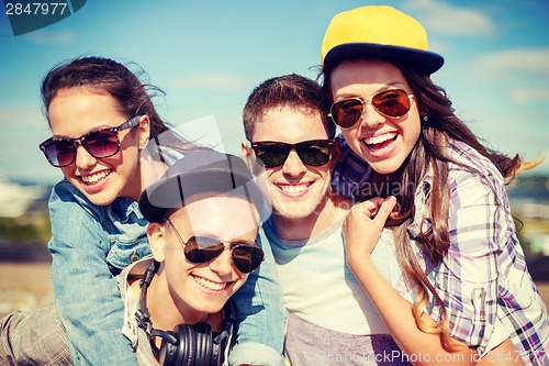 Image of group of smiling teenagers hanging out