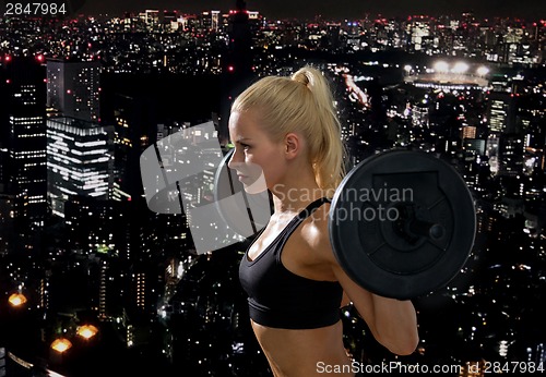 Image of sporty woman exercising with barbell
