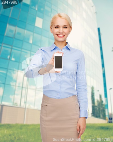 Image of smiling businesswoman with smartphone blank screen