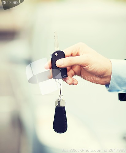 Image of man with car key outside