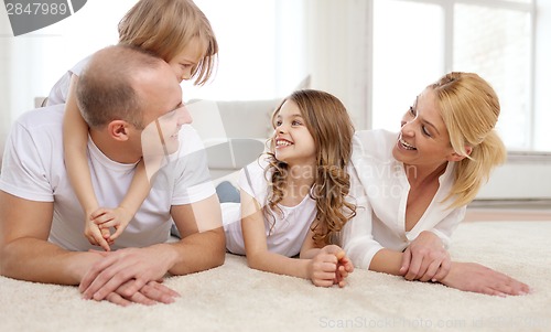 Image of parents and two girls lying on floor at home