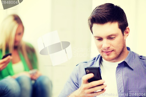 Image of student looking at phone and tiping