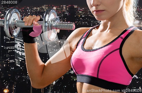 Image of close up of sporty woman with heavy steel dumbbell