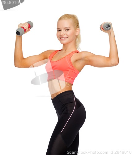 Image of smiling beautiful sporty woman with dumbbells