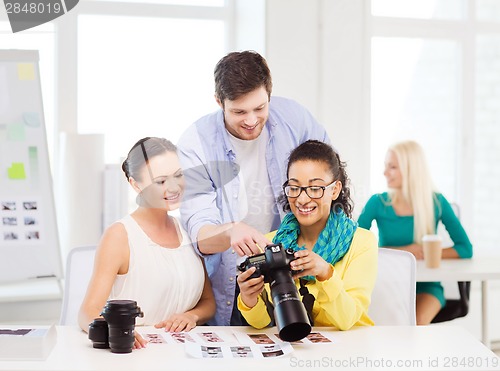 Image of smiling team with photocamera working in office