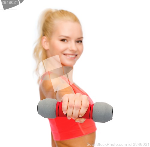 Image of smiling beautiful sporty woman with dumbbell