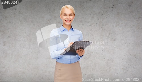 Image of smiling businesswoman with clipboard and pen