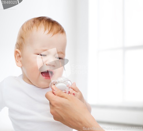 Image of crying baby with dummy