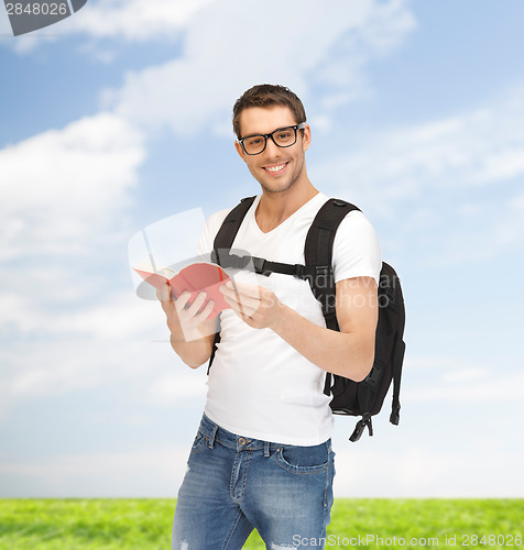 Image of travelling student with backpack and book