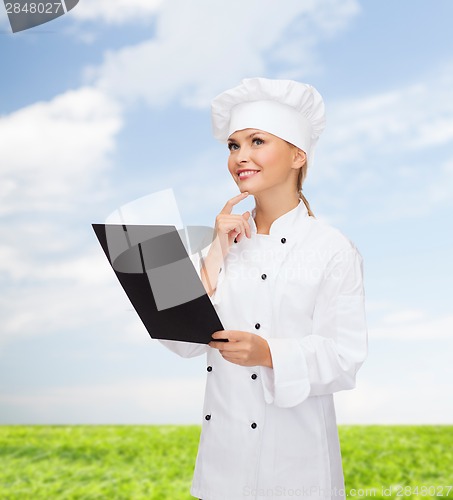 Image of smiling female chef with black blank paper