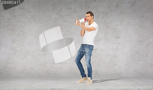 Image of handsome man with megaphone over concrete wall