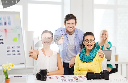 Image of smiling team with photocamera in office