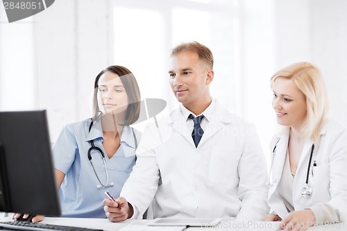 Image of doctors looking at computer on meeting