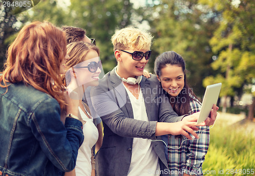 Image of teenagers taking photo with tablet pc outside