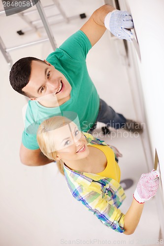 Image of smiling couple doing renovations at home