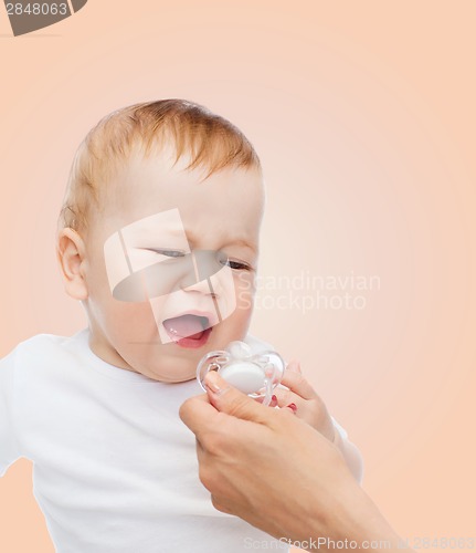 Image of crying baby with dummy