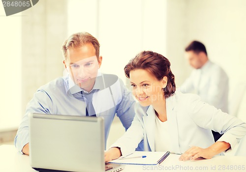 Image of man and woman working with laptop in office