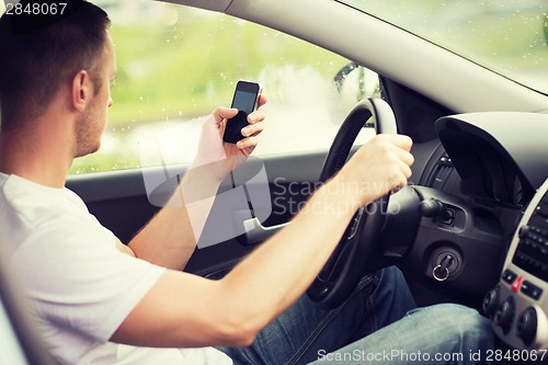 Image of man using phone while driving the car