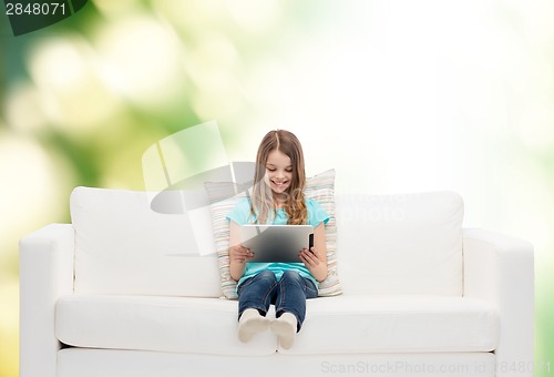 Image of little girl sitting on sofa with tablet pc