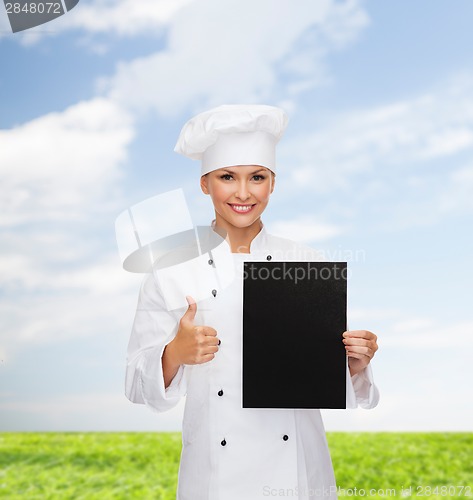 Image of smiling female chef with black blank paper