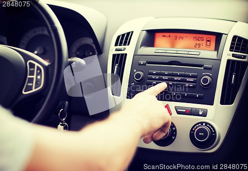 Image of man using car audio stereo system