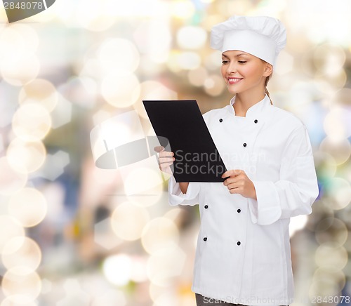 Image of smiling female chef with black blank paper