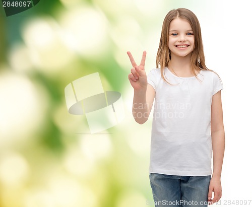 Image of little girl in white t-shirt showing peace gesture