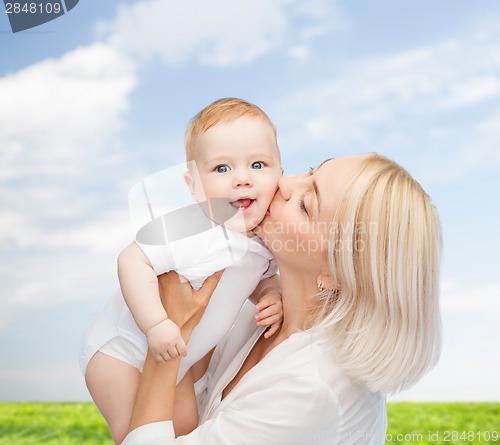 Image of happy mother kissing smiling baby