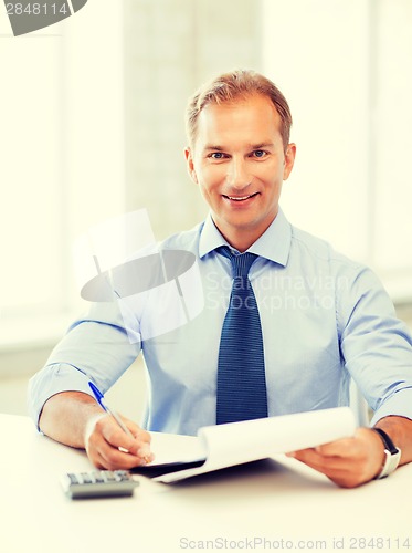Image of businessman with notebook and calculator
