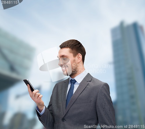 Image of young smiling businessman with smartphone