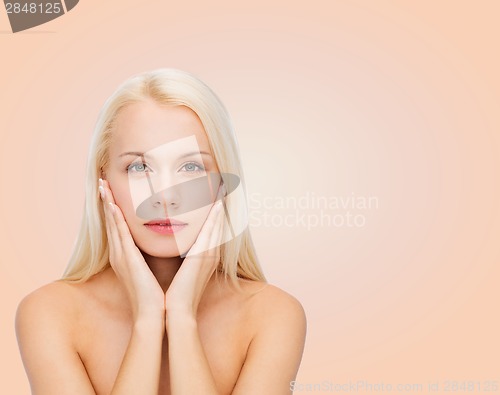 Image of beautiful woman touching her face skin