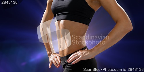 Image of close up of athletic female abs in sportswear