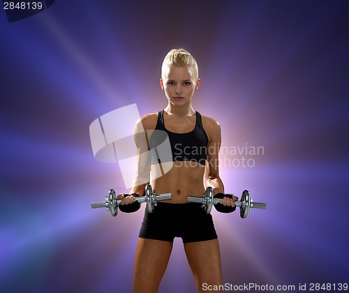 Image of sporty woman with heavy steel dumbbells