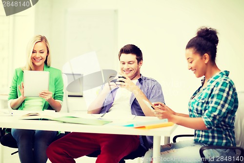 Image of students looking into devices at school