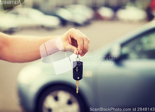 Image of man with car key outside