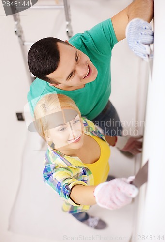 Image of smiling couple doing renovations at home