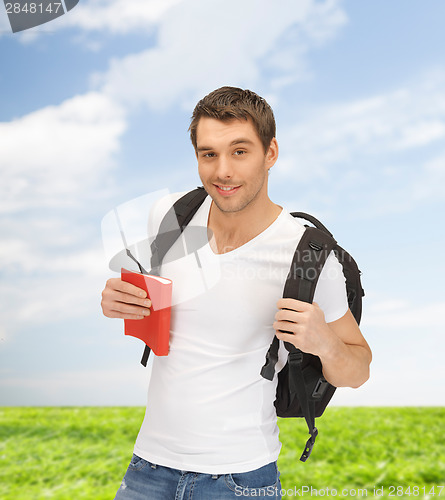 Image of travelling student with backpack and book