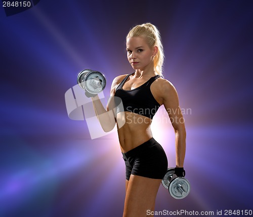 Image of sporty woman with heavy steel dumbbells