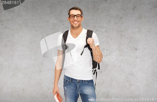 Image of smiling student with backpack and book