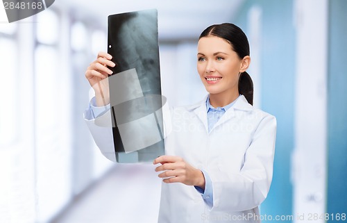 Image of smiling female doctor looking at x-ray