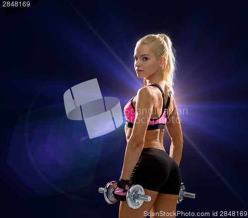 Image of sporty woman with heavy steel dumbbells