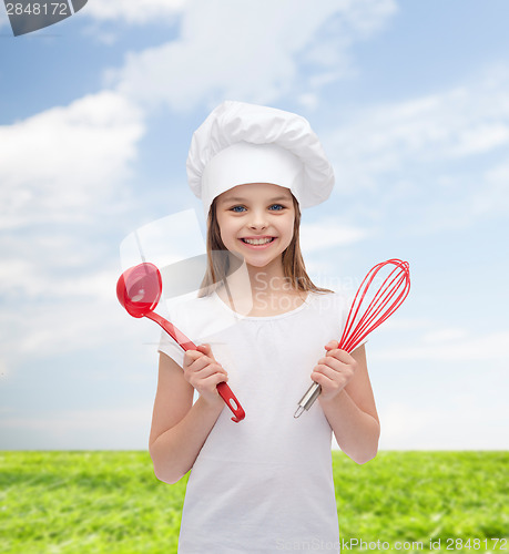 Image of smiling girl in cook hat with ladle and whisk