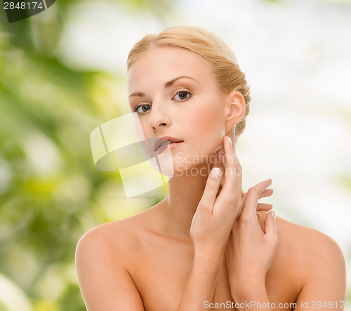 Image of beautiful woman touching her face skin